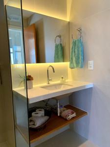 a bathroom with a sink and a mirror at Apartamento vista do mar, pé na areia e águas tranquilas, no cento de Guarapari in Guarapari +25 photos