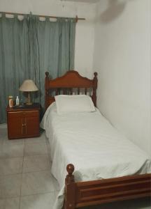 - une chambre avec un lit et une table avec une lampe dans l'établissement Dpto parque Avellaneda, à San Miguel de Tucumán