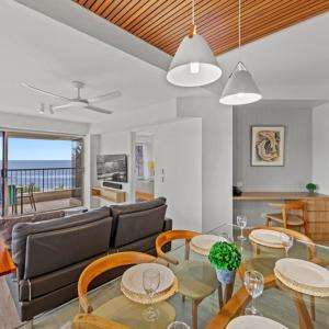 sala de estar con sofá, mesa y sillas en Costa Nova Holiday Apartments, en Sunshine Beach