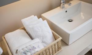 a basket of towels sitting next to a sink at Gapyeong Parotia Waterhouse in Gapyeong