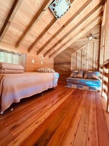 1 dormitorio con 2 camas y suelo de madera en Casa Violeta, en Urubici