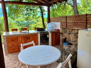 cocina con mesa blanca, mesa y sillas en Estancia Arboreto - Reserva Natural, en Barichara