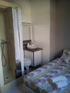 a bathroom with a bed and a sink and a toilet at Auberge Bella Riva in Creysse