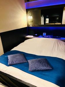 a bed with two pillows on top of it at ホテル CROWN MOTEL in Yokohama