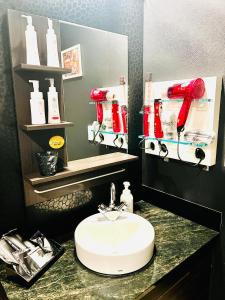 a bathroom with a sink and a red soap dispenser at ホテル CROWN MOTEL in Yokohama