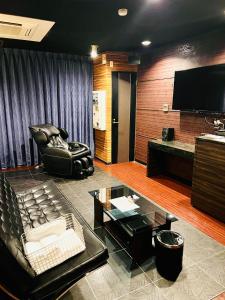 a living room with a couch and a flat screen tv at ホテル CROWN MOTEL in Yokohama