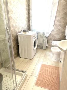 a bathroom with a shower and a washing machine at Minù house in Scalea