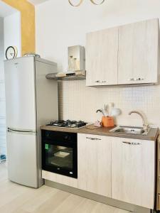 La cuisine est équipée d'un réfrigérateur blanc et d'un évier. dans l'établissement Minù house, à Scalea