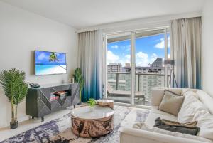 a living room with a couch and a large window at Luxury High Floor Corner 1BR Unit at W Resort Fort Lauderdale-Well stocked in Fort Lauderdale