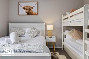 1 dormitorio con 1 cama blanca y literas en Banksia 15, en Kalkite