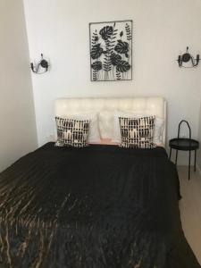 1 dormitorio con 1 cama con almohadas blancas y negras en Luxury Old Town apartment, en Vilna