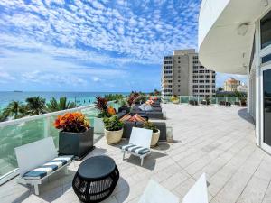 a patio with chairs and a view of the ocean at Luxury High Floor Corner 1BR Unit at W Resort Fort Lauderdale-Well stocked in Fort Lauderdale