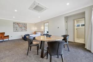 a room with a table and chairs and a bed at Central Caleula Motor Lodge in Orange