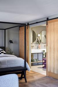 a bedroom with a black canopy bed and wooden doors at Central Caleula Motor Lodge in Orange