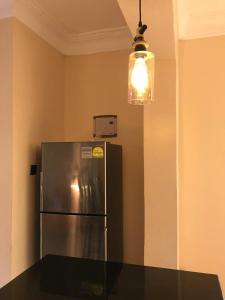 a kitchen with a stainless steel refrigerator and a light at Amazing lake Victoria Villa, Entebbe in Entebbe