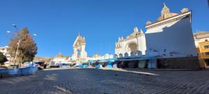 a cobblestone street in front of a white building at Hostal Sol y Luna in Copacabana