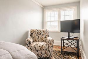 a bedroom with a chair and a flat screen tv at Historic Hagerstown Antietam Battlefield WhiteTail in Hagerstown