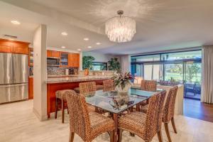 a dining room with a glass table and chairs at Kaanapali Royal D101 in Lahaina