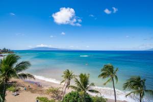 a view of a beach with palm trees and the ocean at Sands of Kahana 355 in Kahana