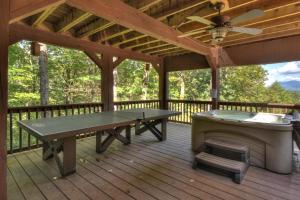 a covered deck with a ping pong table and a grill at Bella Vista in Ellijay