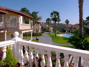 a white fence in front of a house with a pool at HG Jardín de Menorca in Son Bou
