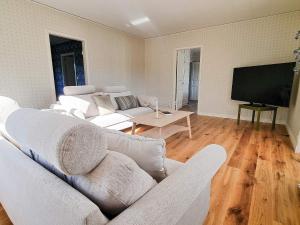 een woonkamer met witte meubels en een flatscreen-tv bij Holiday home Moheda II in Moheda