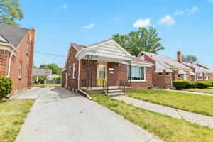 dom z czerwonej cegły z żółtymi drzwiami w obiekcie Comfy Family-Friendly Getaway less than 15 mins to Downtown w mieście Detroit