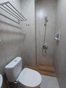 y baño con aseo blanco y lavamanos. en Grownicle Living, en Timuran