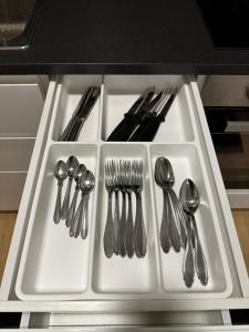 a white tray with forks and spoons and forks and silverware at Villa i centrala Borås nära sjö, centralstationen in Borås