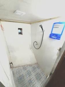 a bathroom with a shower with a phone on the wall at Boat Open Trip Komodo 3Days 2 Nigths in Labuan Bajo
