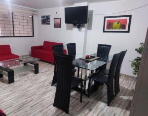 uma sala de estar com uma mesa e um sofá vermelho em Apartamento en El Rodadero, Santa Marta em Santa Marta
