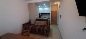 een kleine woonkamer met een bank en een keuken bij Departamentos Solares - O'Higgins in Bahía Blanca