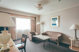 a hotel room with a couch and a table at Numazu River Side Hotel in Numazu