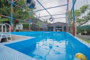 an empty swimming pool with blue water in a building at Jeju Best Hill in Jeju