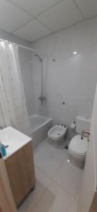 een witte badkamer met een toilet en een wastafel bij Departamentos Solares - O'Higgins in Bahía Blanca