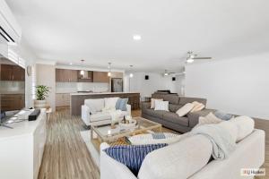 a living room with two couches and a kitchen at Casa Palmera in Casuarina