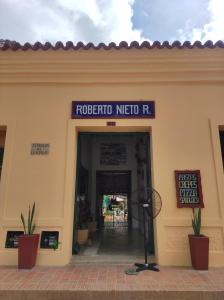 蒙波斯的住宿－HOTEL NIETO MOMPOX, ubicado en el corazón del centro histórico, frente al rio magdalena en zona de malecón，带有读过罗伯托伊托内德诺尔的标志的建筑物