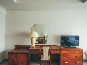 a desk with a television and a lamp on it at Kakegawa Grand Hotel in Kakegawa