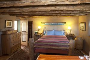 Un dormitorio con una cama grande con almohadas azules. en Casa Gallina - An Artisan Inn, en Taos