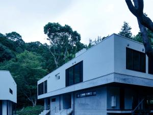 a white house with trees in the background at Boscage Kariya in Yugawara