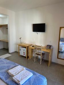 a bedroom with a desk with a television and a chair at Villa Dom Felippe in Jericoacoara