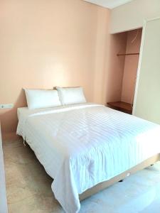 1 dormitorio con 1 cama grande con sábanas blancas en Grownicle Living, en Timuran