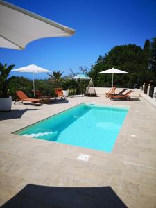 a swimming pool with chairs and umbrellas on a resort at Peiranze144 b&b in Sanremo