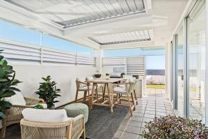 a dining room with a table and chairs at Belle Escapes - Paradise on the Beach in Somerton Park