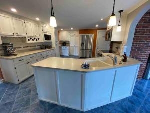 a large kitchen with white cabinets and a sink at Red Brick Farm House in Kentville