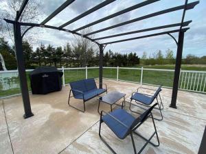 a pergola with chairs and chairs on a patio at Red Brick Farm House in Kentville