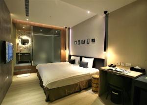 a hotel room with a bed and a desk in it at G11 Hotel in Taichung