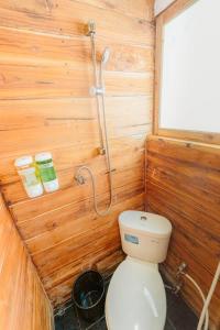 a small bathroom with a toilet and a shower at Boat Open Trip Komodo 3Days 2 Nigths in Labuan Bajo