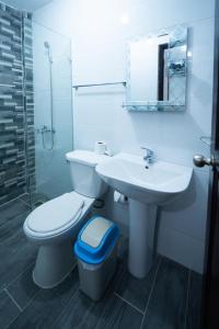 een witte badkamer met een toilet en een wastafel bij Hotel porto escondido in Santa Bárbara de Samaná