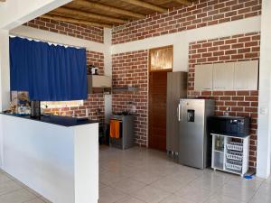 cocina con pared de ladrillo y nevera en Vichayito, Villa Chalaca, en Vichayito